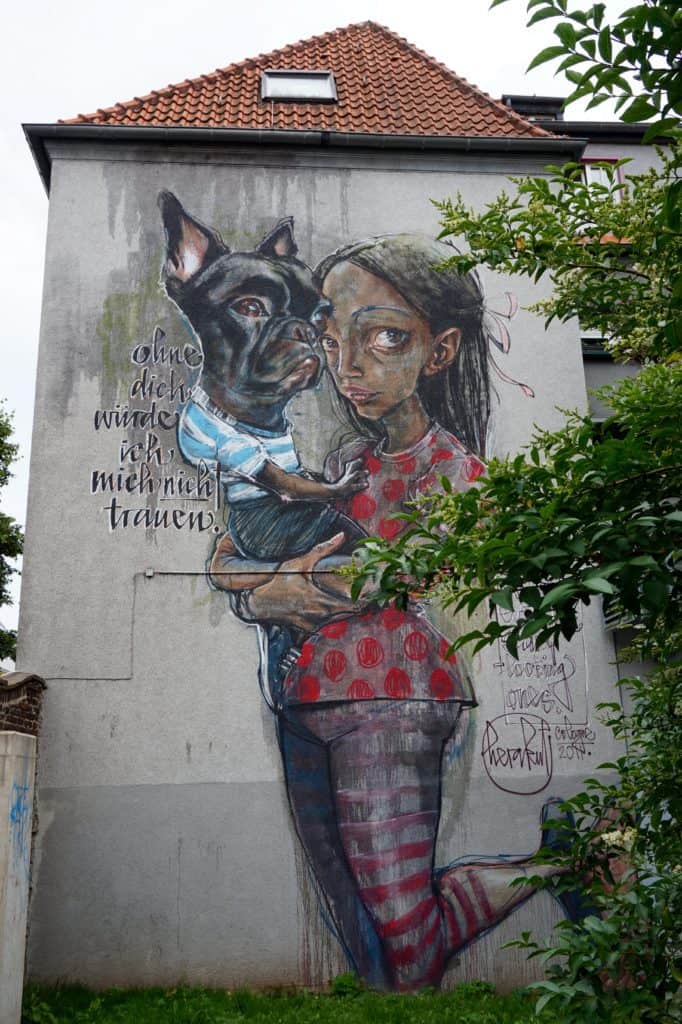 Streetart Juli 2017, Köln, komplette Fassade, Ehrenfeld, Frau mit Hund auf dem Arm 