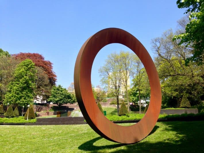 Sklupturengarten hinter dem Abteiberg Museum in Mönchengladbach, rostiger Stahlring, Blick auf das Museum, Bäume, Blauer Himmel